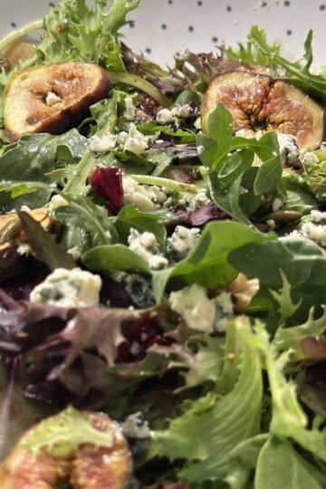 A bowl with figs and blue cheese maple glazed salad