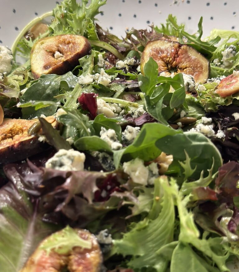 A bowl with figs and blue cheese maple glazed salad