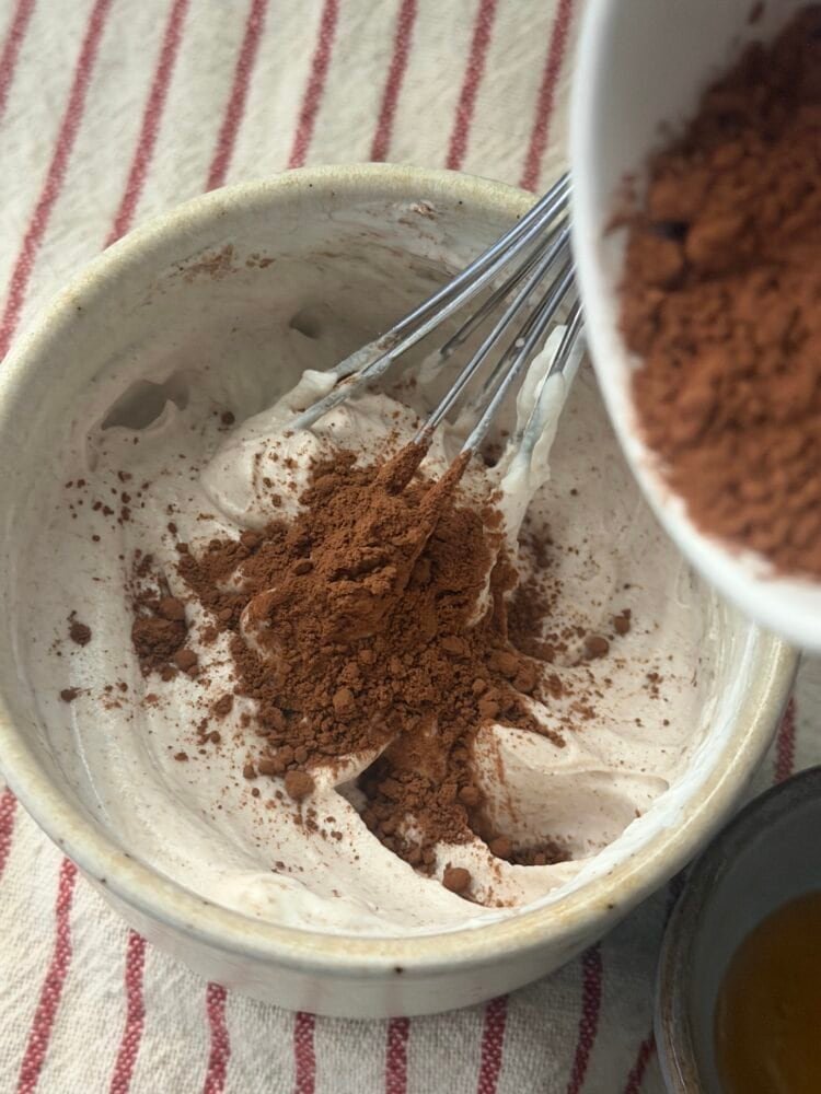 Add the protein powder and dark cocoa, then whisk with a small whisk until smooth and there are no dry spots left.n